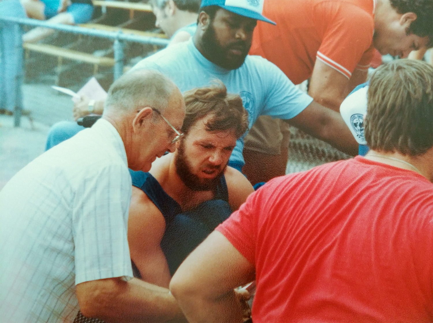 Rory Cooper in the 1980s w grandfather Rory Munn and Tim David peer mentor in red shirt doing work on Rory’s racing wheelchair