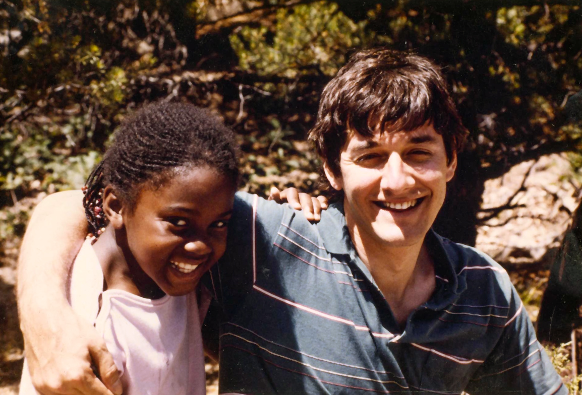 Martine Rothblatt and daughter Sunee around age three in 1980 in Los Angeles, arms around each other, outside in front of trees.