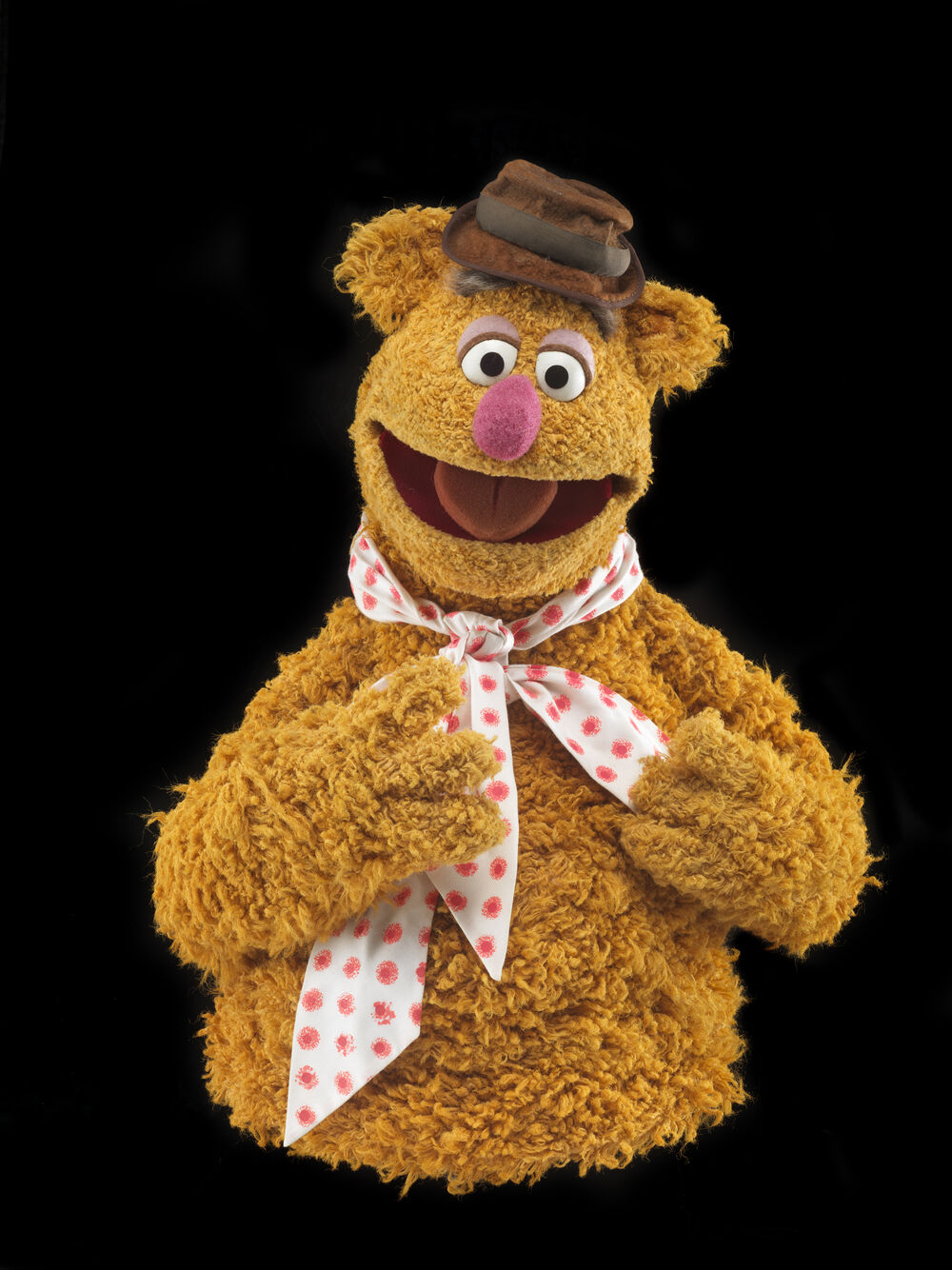 The Fozzie Bear puppet, created by Jim Henson, wearing a hat and polka dot bow tie.