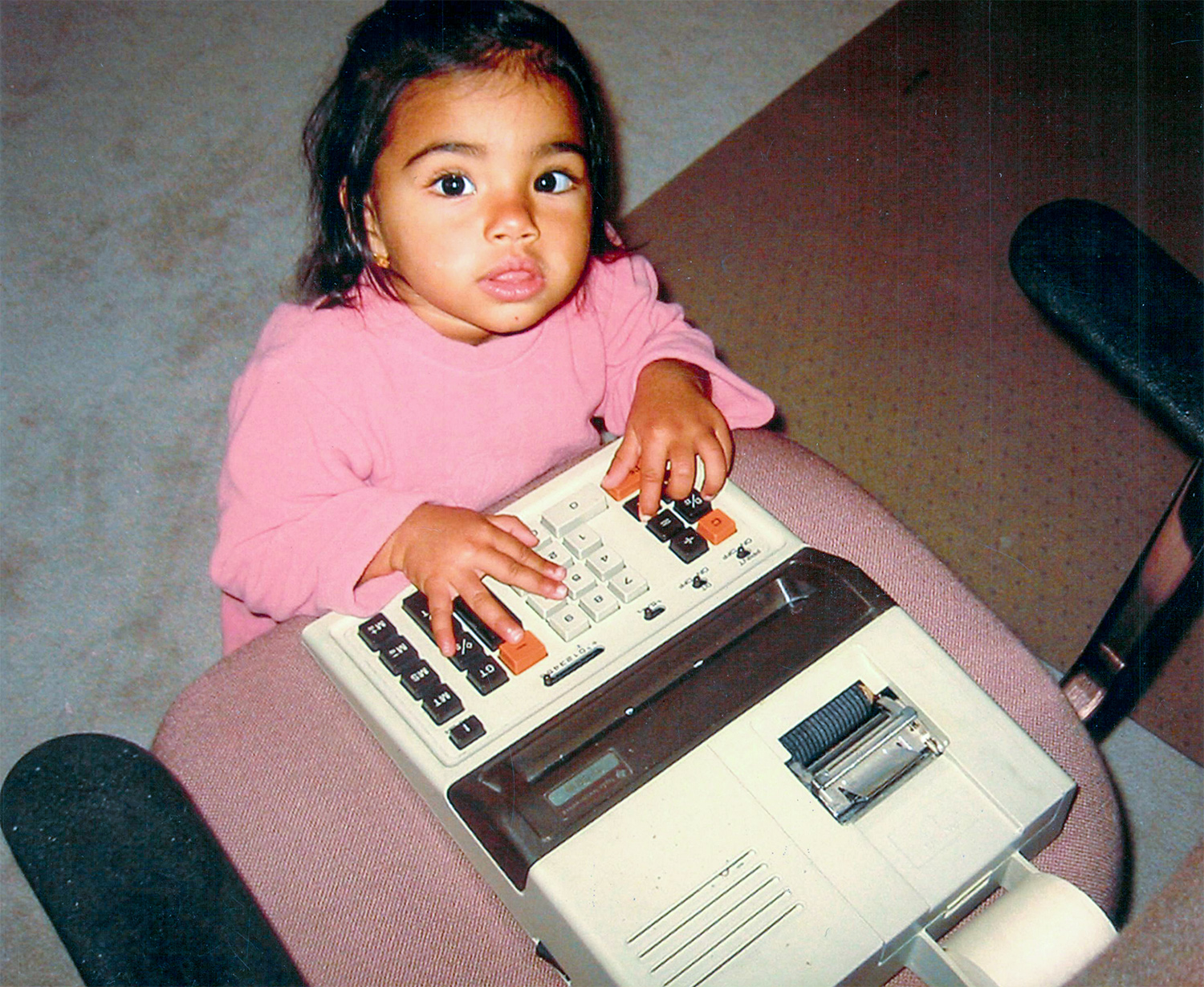 Sangeeta Bhatia, age 2, places both hands on a large calculator.