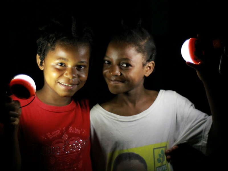 Image: Two girls holding Nokero solar light