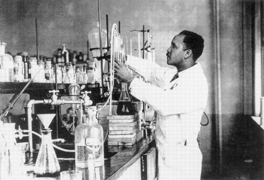 一名身穿白大衣的男子在实验室里操作设备。